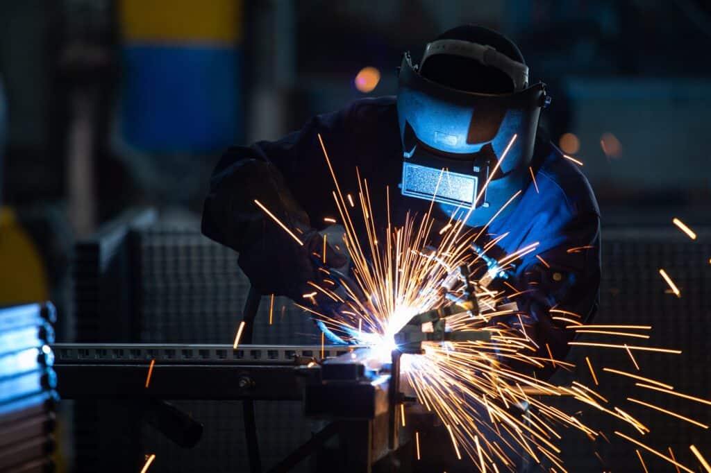 A welder wearing mask with sparks.
